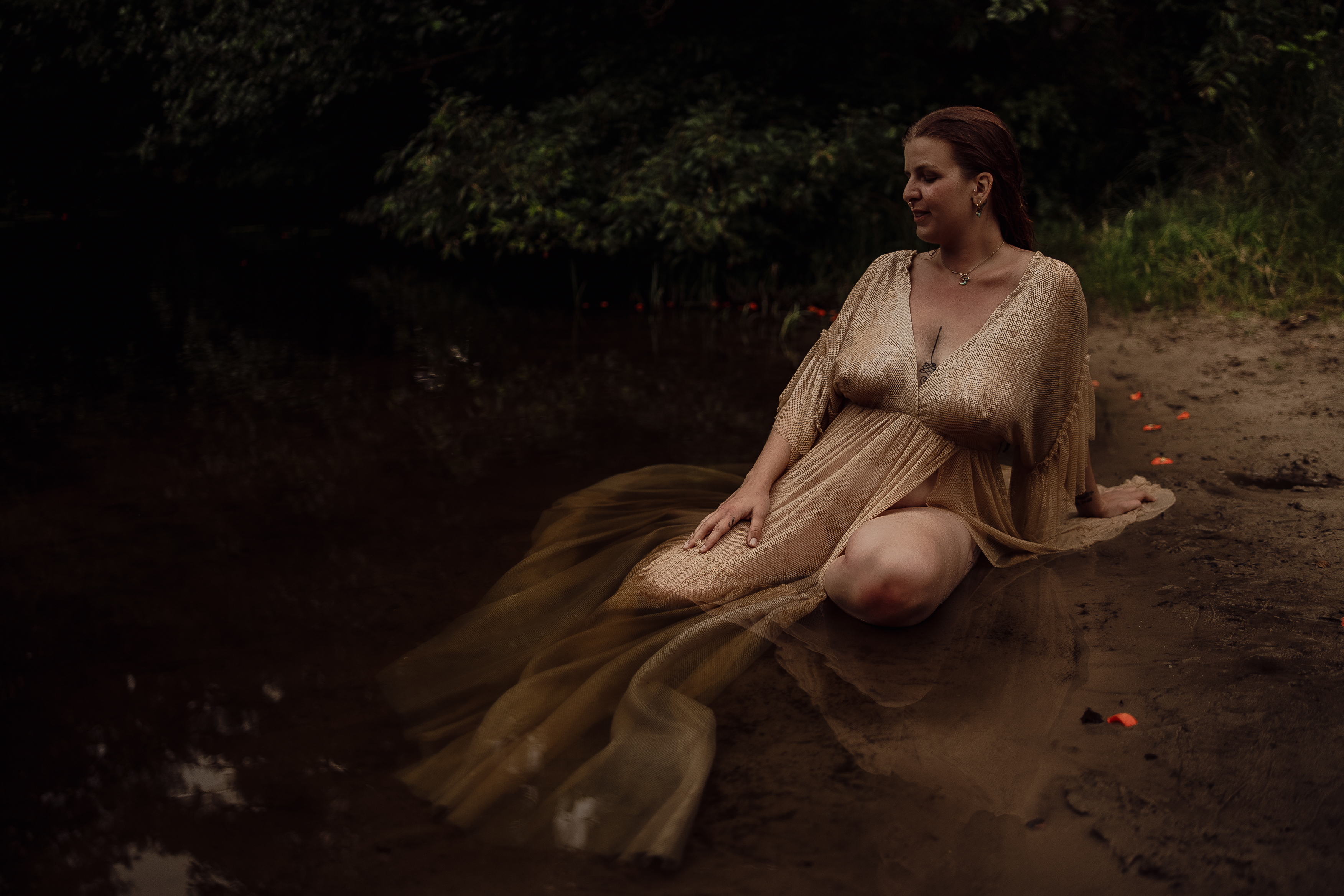 Frau im goldenen Kleid am Wasser